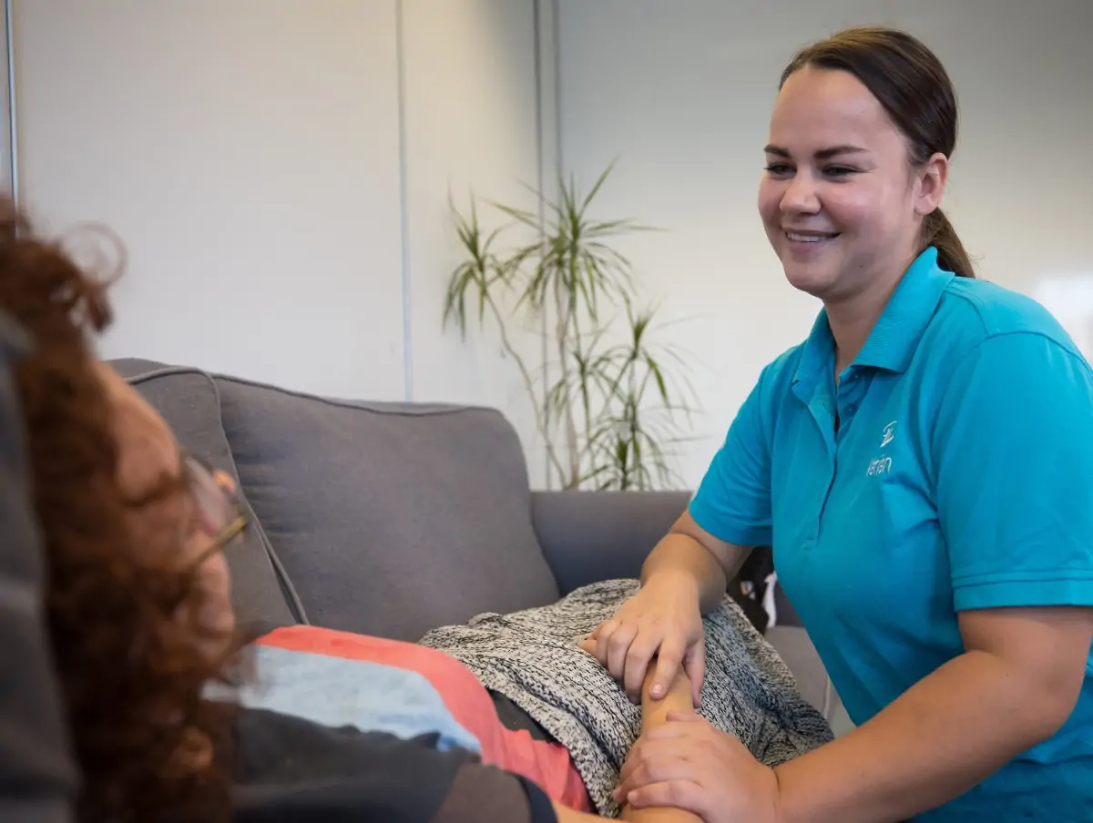 Zorgverlener Vérian technoteam cliënt op de bank